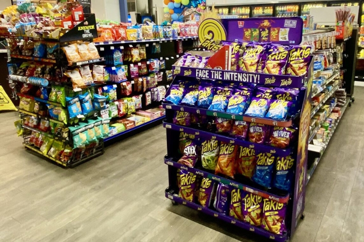 Gondola shelving in a retail store filled with chips and snacks