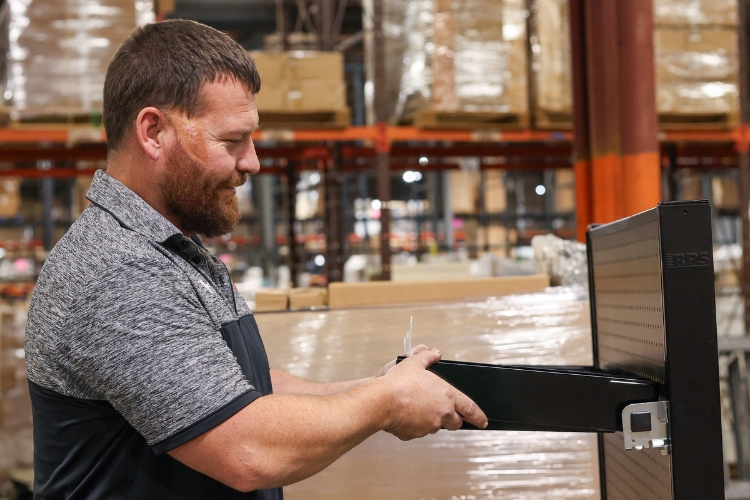RPS staff member installing custom retail display shelving